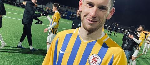 Ein Spieler von Hessen Kassel trägt ein blau-gelbes Sondertrikot.