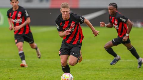 Die drei Spieler der Eintracht Frankfurt II hinter dem Ball.