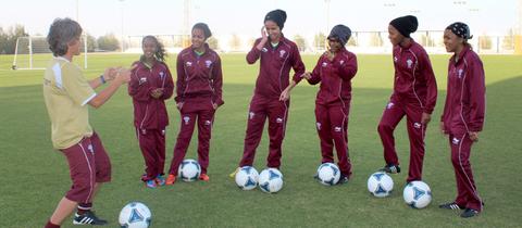 Monika Staab mit Fußballerinnen in Katar