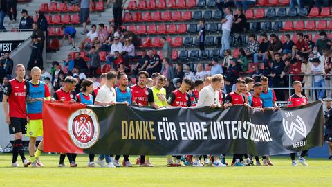 Die SVWW-Spieler tragen ein Banner über den Platz, mit dem sie sich für die Unterstützung der Fans bedanken.