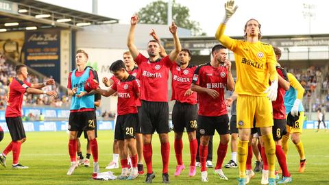 Die Spieler des SV Wehen Wiesbaden hüpfen vor Freude.