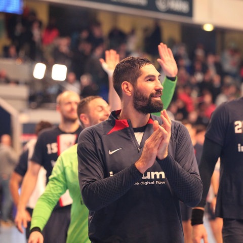 Nikola Karabatic applaudiert, im Hintergrund winken andere Spieler von PSG ins Publikum.