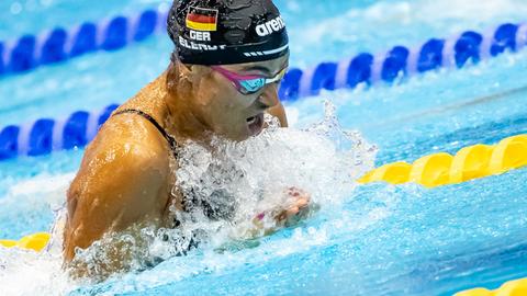 Anna Elendt schwimmt im Becken mit schwarzer Badekappe.