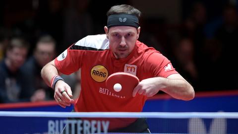 Timo Boll trifft mit konzentriertem Blick den Ball