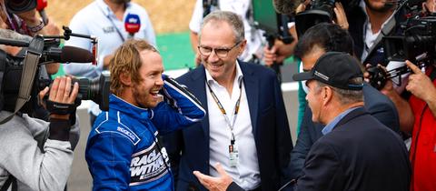 Sebastian Vettel und Formel-Boss Stefano Domenicali im Gespräch mit zwei anderen Männern.