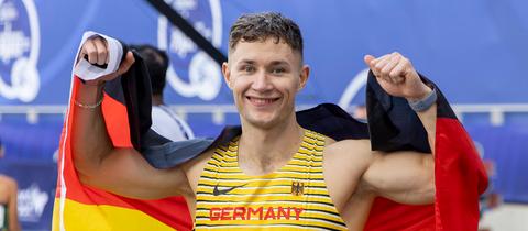 Felix Streng mit Grinsen auf dem Gesicht und Deutschland-Flagge in der Hand.