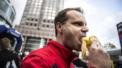 Ein Teilnehmer des Frankfurt Marathon isst eine Banane.