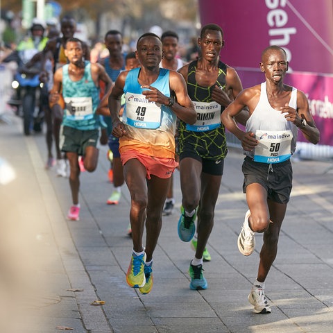 Der Kenianer Brimin Misoi (M), späterer Sieger des Marathon 2022 in Frankfurt, läuft neben Mailu Samwel Nyamai (KEN, r), und Kwambai Elkana Kibet (KEN, l) durch die Stadt.