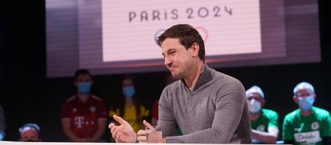 Timo Boll im Aktuellen Sportstudio. Im Hintergrund ist das Logo der Olymischen Spiele 2024 zu sehen.