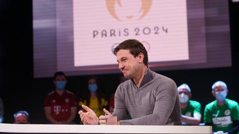 Timo Boll im Aktuellen Sportstudio. Im Hintergrund ist das Logo der Olymischen Spiele 2024 zu sehen.