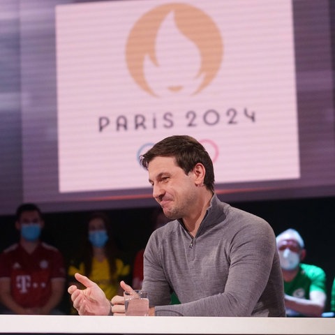 Timo Boll im Aktuellen Sportstudio. Im Hintergrund ist das Logo der Olymischen Spiele 2024 zu sehen.