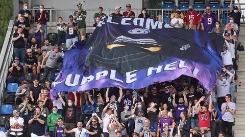 Fans der Frankfurt Galaxy halten eine Fahne mit der Aufschrift "Welcome to Purple Hell" hoch.