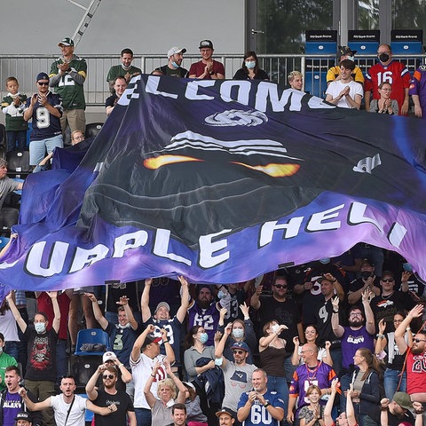 Fans der Frankfurt Galaxy halten eine Fahne mit der Aufschrift "Welcome to Purple Hell" hoch.