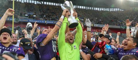 Thomas Kösling hebt den Pokal in die Höhe.