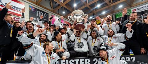 Spieler und Beteuer der Löwen Frankfurt jubeln mit dem DEL2-Pokal