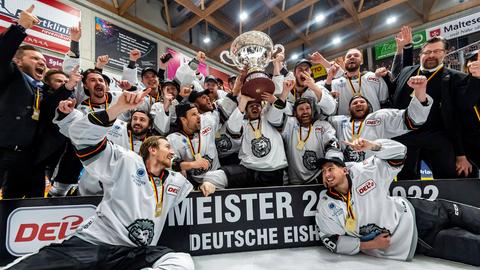 Spieler und Beteuer der Löwen Frankfurt jubeln mit dem DEL2-Pokal