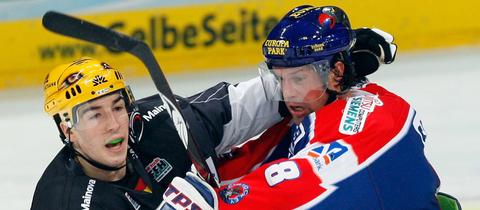 Zwei Eishockey-Spieler prügeln sich.