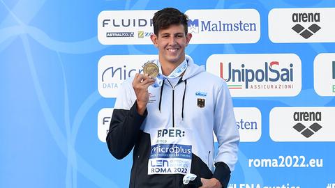 Lucas Matzerath zeigt seine Bronzemedaille, die ihm um den Hals hängt