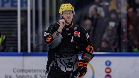 Ville Lajunen öffnet die Schnalle am Eishockey-Helm.