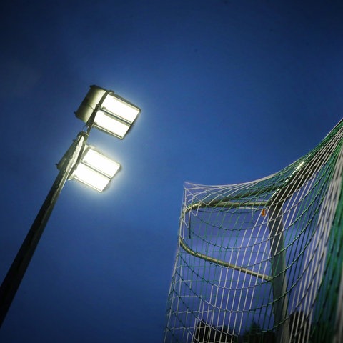 Ein Flutlicht strahlt auf den Fußballplatz