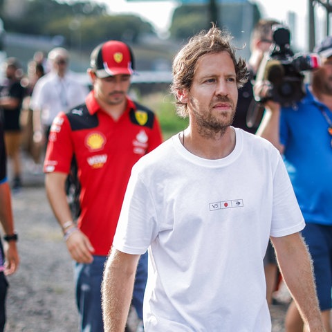 Sebastian Vettel dahinter zwei aktuelle Formel 1-Rennfahrer und ein Kameramann.