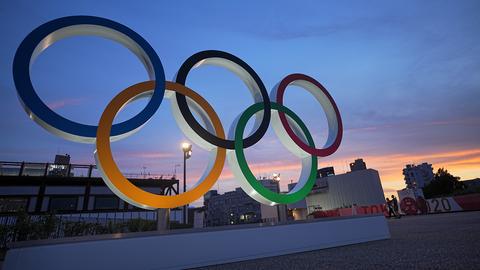 Die Olympischen Ringe stehen in der Abenddämmerung