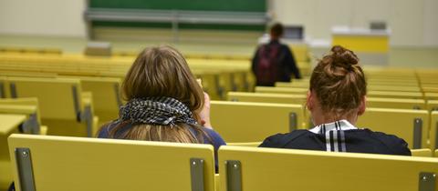 Hörsaal einer Uni mit zwei Personen von hinten