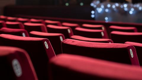 Theater mit roten Polsterstühlen, Bühne mit Lichtern