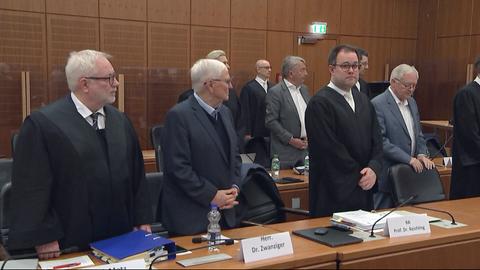 Männer mit ihren Anwälten im Gerichtssaal