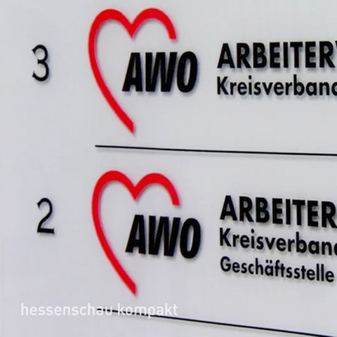 Das Foto zeigt ein Schild mit der Aufschrift "AWO Kreisverband Wiesbaden e.V." wie es an Hauseingängen zu finden ist.