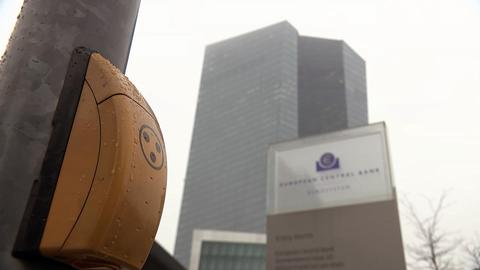 Ein Drückgerät einer Ampel - im Hintergrund die Europäische Zentralbank
