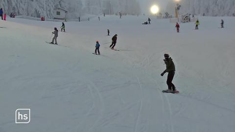 Skifahrer und Snowboarder beim Wintersport am Hang