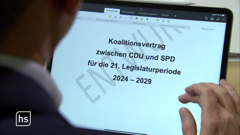 EIn Politiker vor einer Werbetafel der Partei "Bündnis 90 Die Grünen"