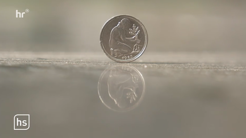 Eine alte 50-Pfennig-Münze, auf der eine kniende Frau zu sehen ist