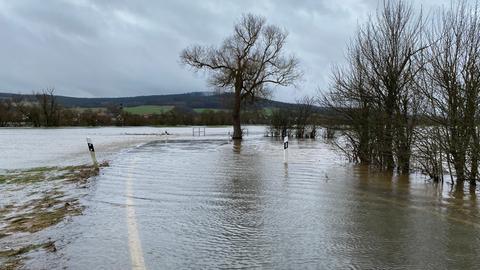 überschwemmte Straße, die Leitplanken stehen im Wasser