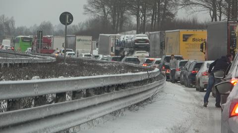 Eine lange Kolonne von Fahrzeugen steht im Stau auf der A7 in Osthessen nach einem erneuten Wintereinbruch mit viel Schneefall.