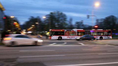 Bus auf Hauptstraße mit Autos in diffusem Licht am Abend