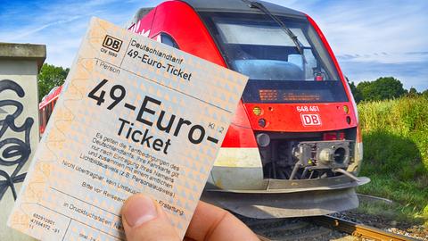 49-Euro-Ticket in der Hand, dahinter Regionalbahn