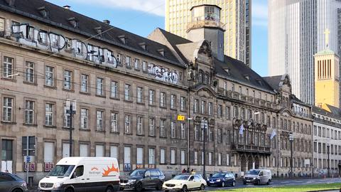 Foto von einem großen historischen Gebäude, das an einer großen städtischen Straße (Frankfurt) steht.