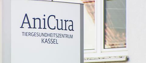 Ein Schild mit der Aufschrift "AniCura. Tiergesundheitszentrum Kassel" steht vor einem Wohnhaus