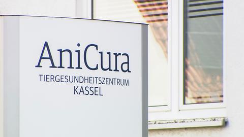 Ein Schild mit der Aufschrift "AniCura. Tiergesundheitszentrum Kassel" steht vor einem Wohnhaus