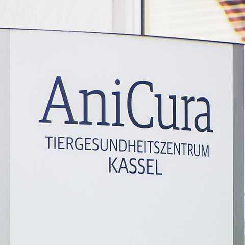 Ein Schild mit der Aufschrift "AniCura. Tiergesundheitszentrum Kassel" steht vor einem Wohnhaus