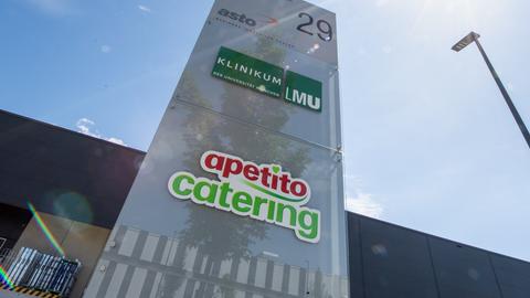 Das Logo vom Klinikum der Universität München und das Logo von Apetito Catering sind auf einer Stele vor einem Gewerbe-Gebäude Gilching zu sehen.