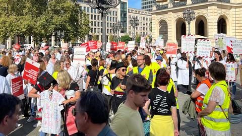 Viele Menschen mit Warnwesten und roten Plakaten vor der Alten Oper.