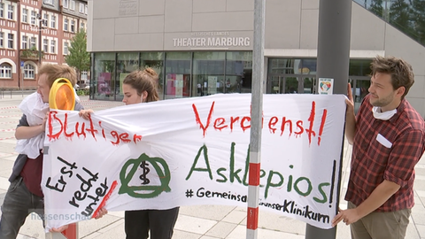 Demonstranten mit Transparent gegen Asklepios.
