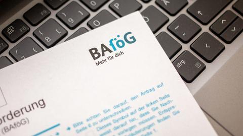 Ein Antrag auf Ausbildungsförderung (Bafög) liegt auf der Tastatur eines Laptopcomputers. 