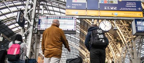 Reisende warten am Frankfurter Hauptbahnhof auf einen Zug.