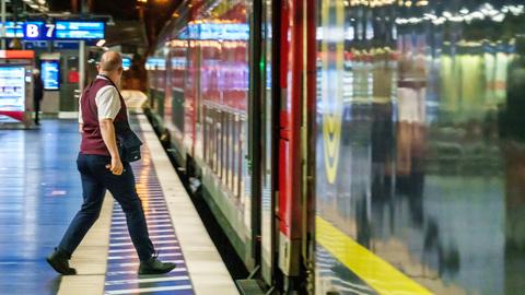 Ein Zugbegleiter steigt kurz vor Abfahrt in den Zug ein.