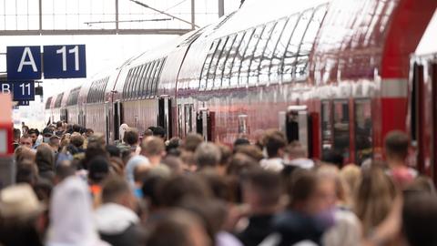 Viele Menschen stehen dicht gedrängt vor einem Zug am Hauptbahnhof Frankfurt