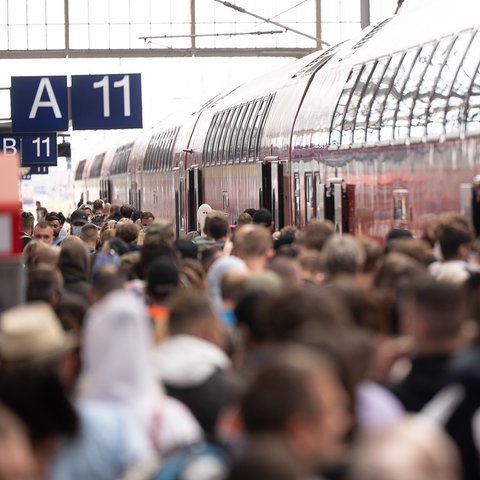 Viele Menschen stehen dicht gedrängt vor einem Zug am Hauptbahnhof Frankfurt